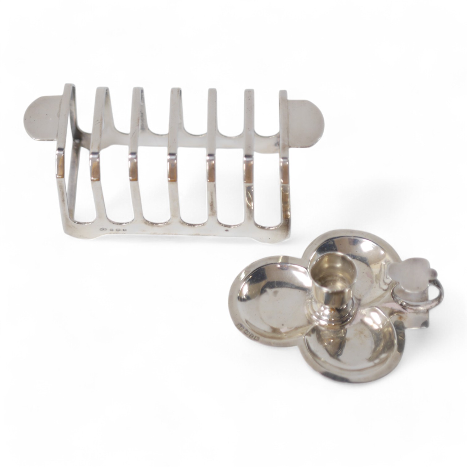 A George VI silver seven bar toast rack, by Elkington & Co, Birmingham, 1947, 14.9cm, together with a late Victorian silver clover shaped chamberstick, by Robert Pringle & Sons, Birmingham, 1899. Condition - fair to good